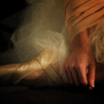 Ballerina sitting only point shoe and hand in frame