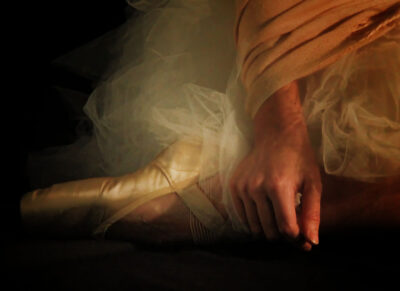 Ballerina sitting only point shoe and hand in frame