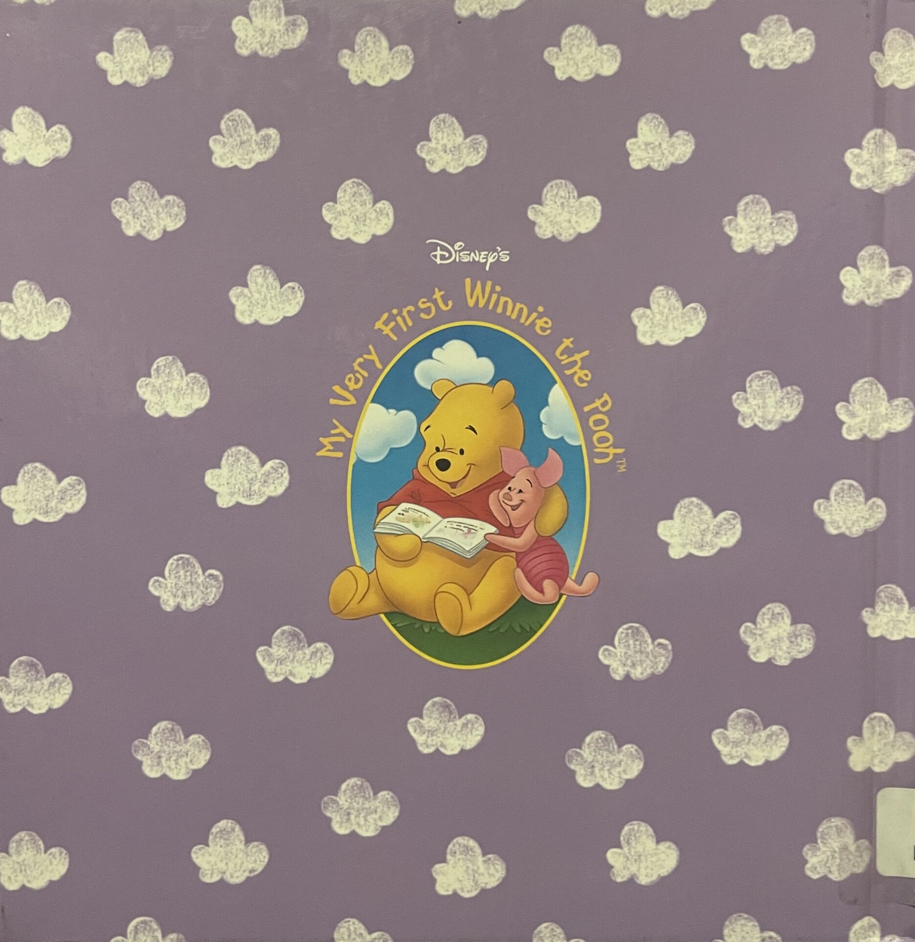 Back of A Bedtime Story for Pooh, featuring a purple sky full of white clouds with a center embed featuring Winnie the Pooh and Piglet reading a book. The emblem is titled "My Very First Winnie the Pooh"
